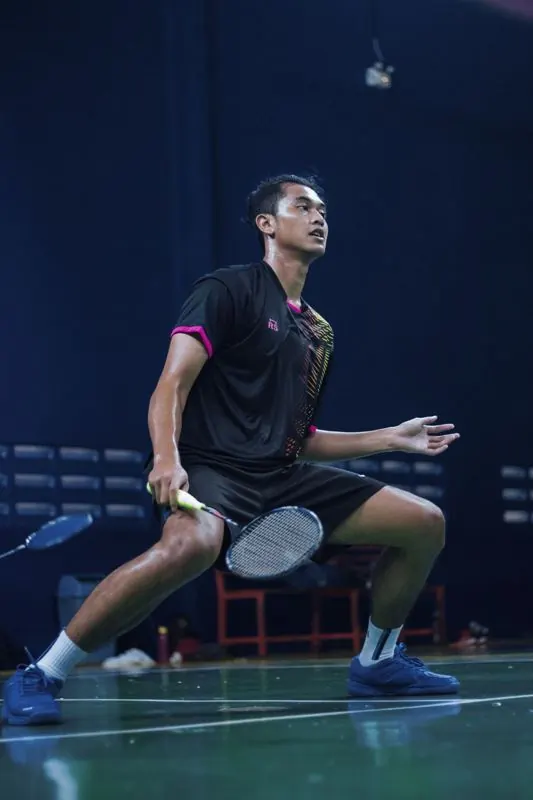 Pemain badminton bersiap menerima kok